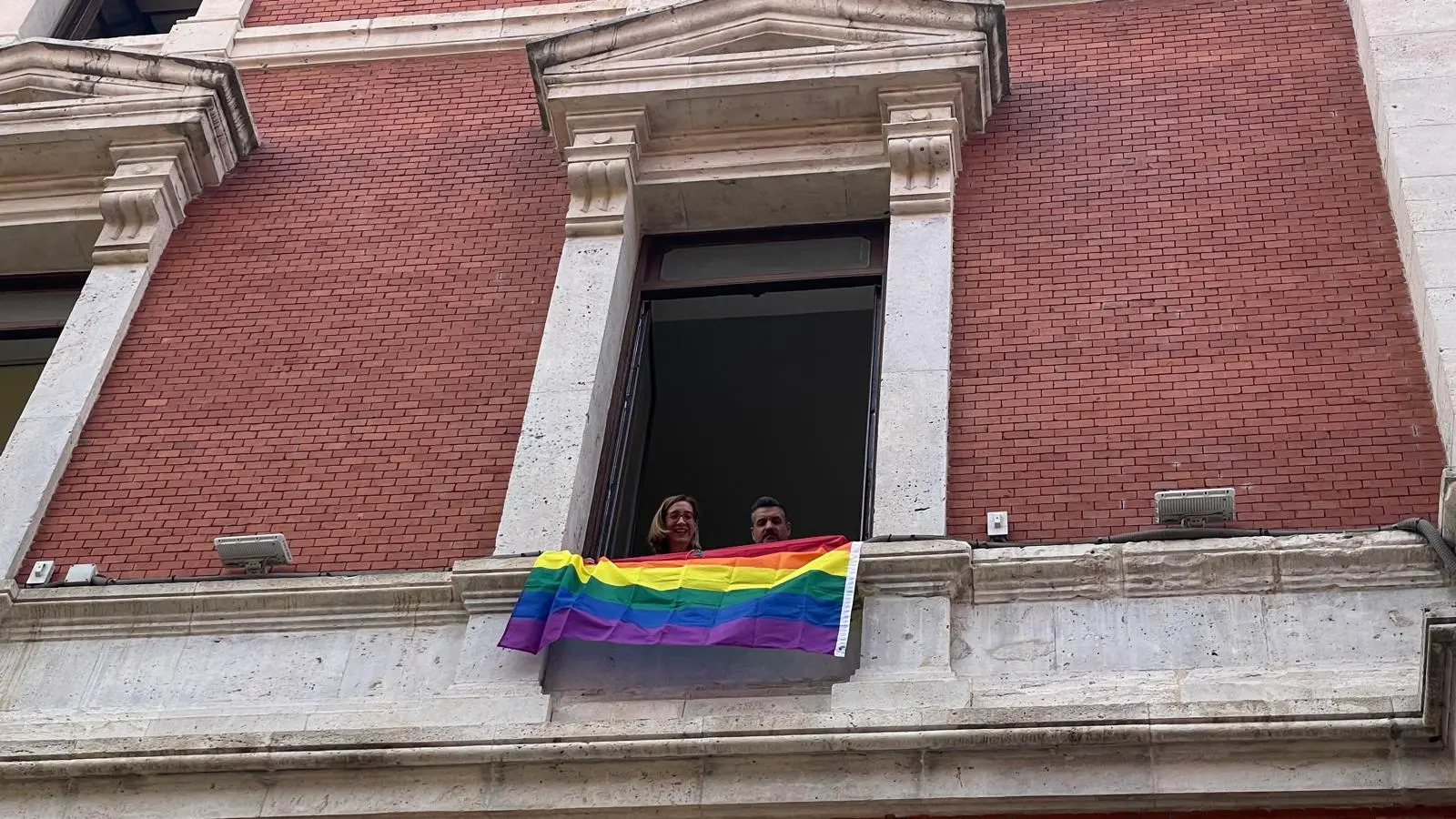 Otro año más sin bandera LGTBI en el ayuntamiento de Valladolid El ayuntamiento de Valladolid, gobernado por PP y Vox, ha decidido no colgar la bandera LGTBI en su fachada durante la celebración del Orgullo este año, generando controversia y reacciones de diversos grupos políticos. Valladolid Toma la Palabra (VTLP) ha expresado su firme rechazo a esta decisión. Jonathan Racionero, portavoz de la formación, ha declarado que "la bandera LGBTI no representa ideología, sino derechos humanos. Ocultarlos sienta precedentes muy peligrosos." VTLP ha anunciado que, a pesar de la decisión del consistorio, colocará la bandera arcoíris desde su grupo municipal "como muestra de reconocimiento, inclusión y respeto". La formación ha enfatizado su compromiso con los derechos y libertades de todas las personas. El acto institucional del Orgullo LGTBI en Valladolid se llevará a cabo mañana, viernes 28 de junio, a las 11 horas en el ayuntamiento. Sin embargo, no se realizará de manera conjunta y consensuada como en años anteriores debido al bloqueo de Vox al acuerdo institucional. Los portavoces de VTLP, PSOE y PP leerán el manifiesto de la Federación Española de Municipios y Provincias (FEMP). Esta situación ha reavivado el debate sobre la visibilidad y el apoyo institucional a la comunidad LGTBI. Defensores de los derechos LGTBI argumentan que la ausencia de símbolos como la bandera arcoíris en edificios públicos puede interpretarse como una falta de reconocimiento y apoyo a la diversidad sexual y de género.